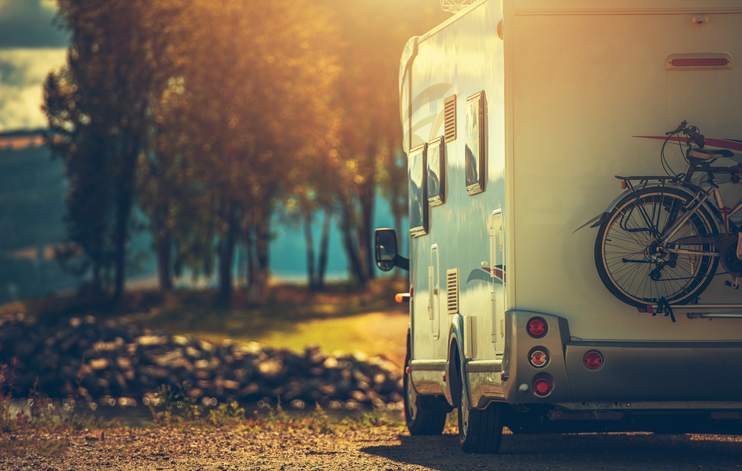Autumn RV Camping. Modern Camper Van During Late Sunny Fall Afternoon. Scenic RV Park.
